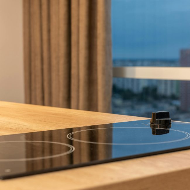 Sleek induction cooktop dans une cuisine moderne avec une vue panoramique sur la ville.