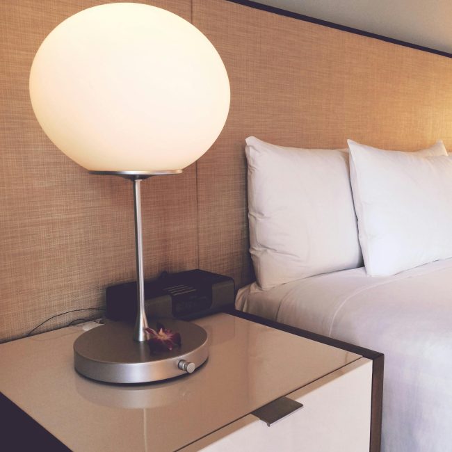 Stylish hotel room featuring soft lighting, elegant bedding, and modern furnishings for a cozy stay. Chambre d'hôtel élégante avec un éclairage doux, une literie raffinée et des meubles modernes pour un séjour cosy.