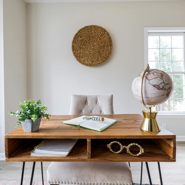 Minimaliste bureau à domicile avec une table en bois, une chaise, un globe et des éléments de décoration pour un design d'intérieur élégant.