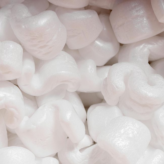Vue détaillée de flocons de calage en polystyrène blanc utilisés pour l'emballage protecteur.