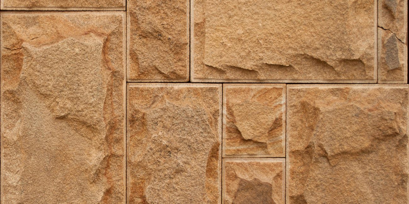 Pierre murale brute aux motifs géométriques et tons terreux pour la conception architecturale.