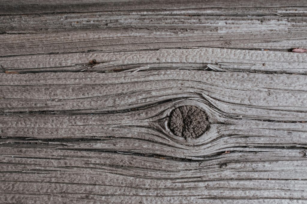 Détail d'une texture de bois vieilli avec des veines et des nœuds visibles. Idéal pour les fonds.
