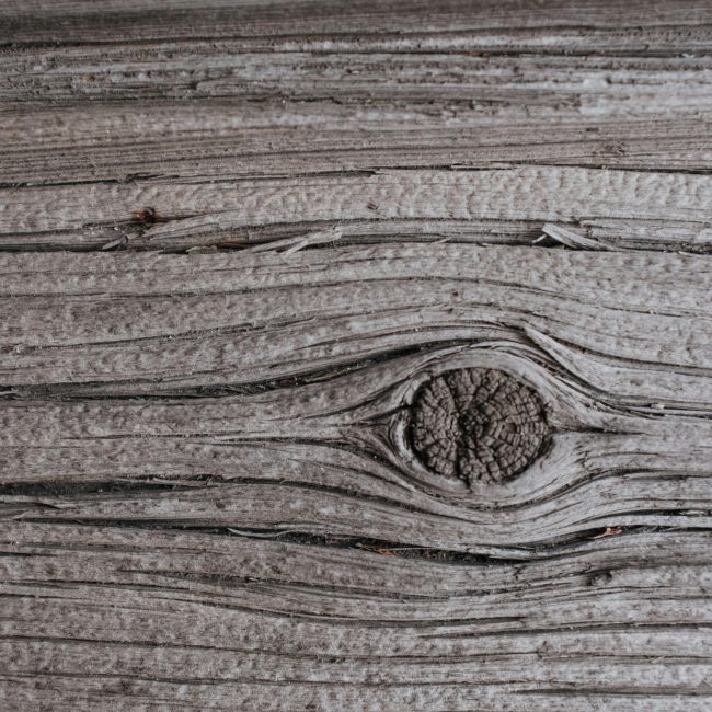 Détail d'une texture de bois vieilli avec des veines et des nœuds visibles. Idéal pour les fonds.