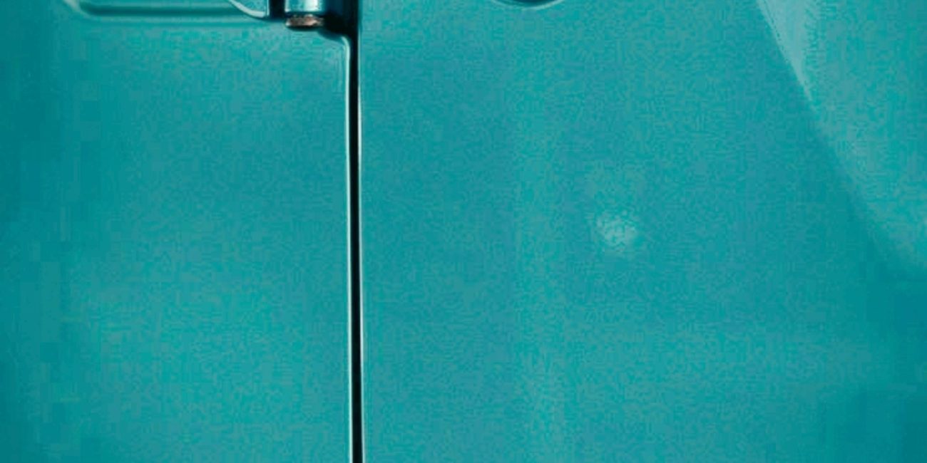 Détail en gros plan d'une charnière de porte de Jeep Wrangler Unlimited en couleur bleu-vert métallisé.