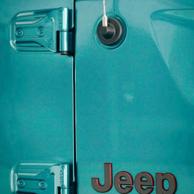 Détail en gros plan d'une charnière de porte de Jeep Wrangler Unlimited en couleur bleu-vert métallisé.