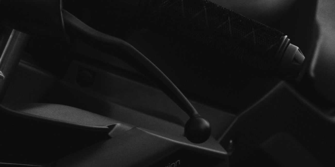 Artistique gros plan en noir et blanc d'un guidon de moto, mettant en valeur un design élégant et les détails.