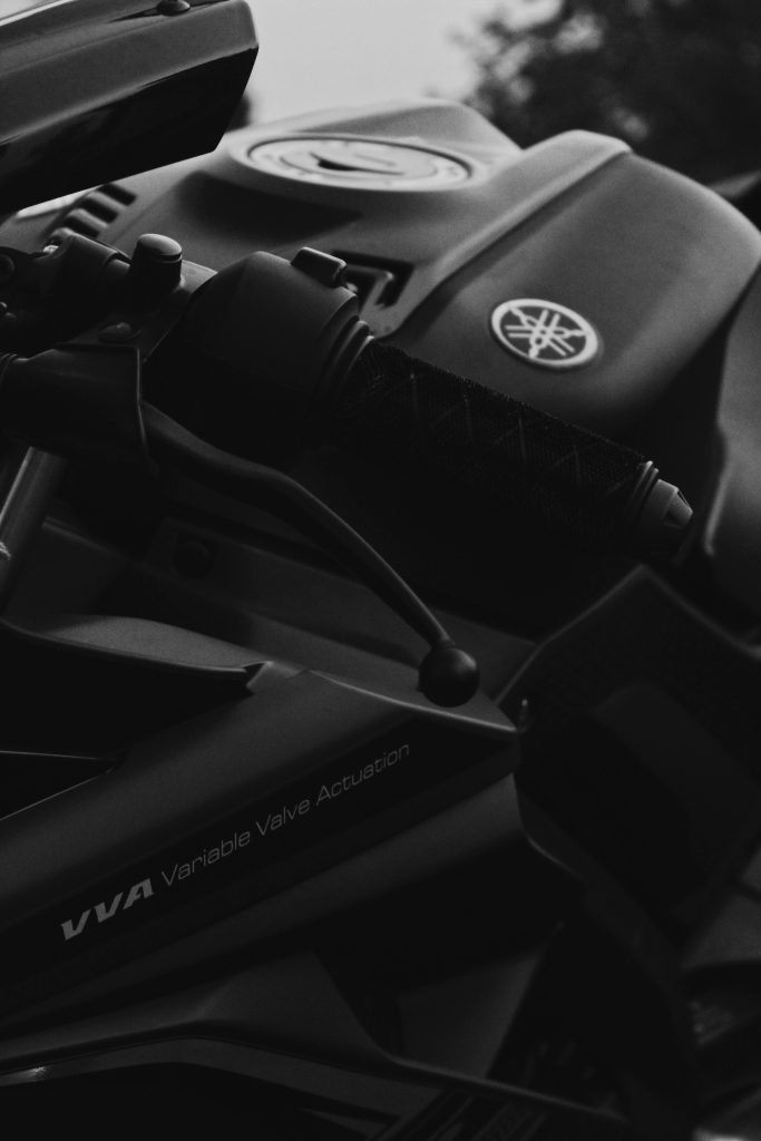 Artistique gros plan en noir et blanc d'un guidon de moto, mettant en valeur un design élégant et les détails.