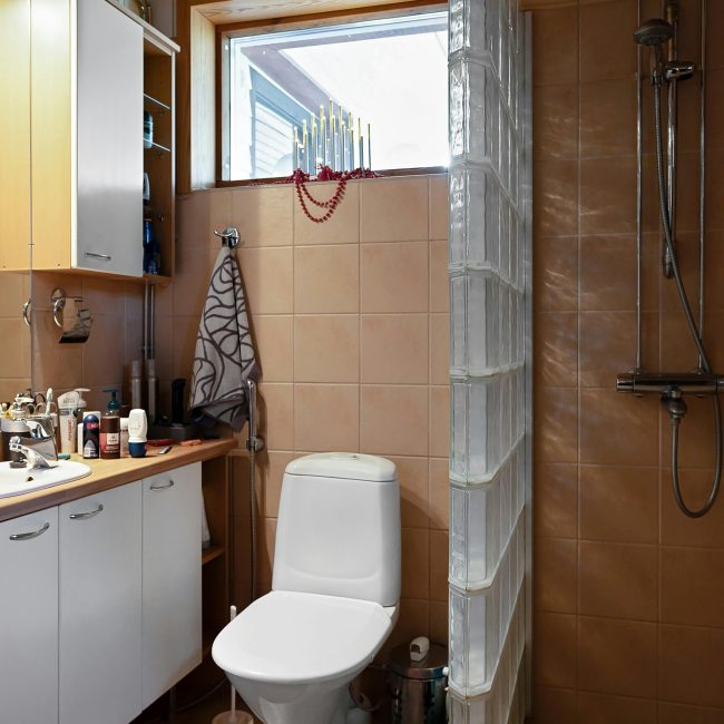 A contemporary bathroom featuring a shower, sink, and vanity with natural light from the window. Salle de bain contemporaine avec douche, lavabo et meuble de toilette baignée de lumière naturelle provenant de la fenêtre.