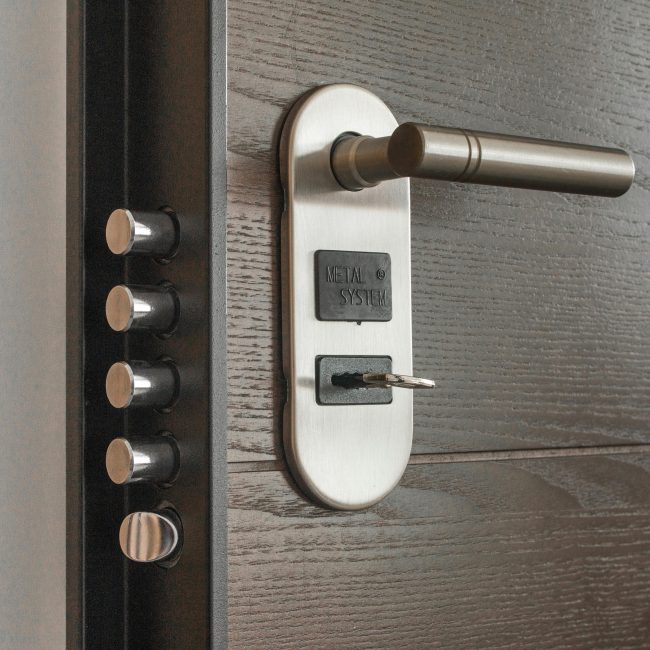 Serrure et poignée de porte en métal avec clé insérée, mettant en avant les caractéristiques de sécurité.
