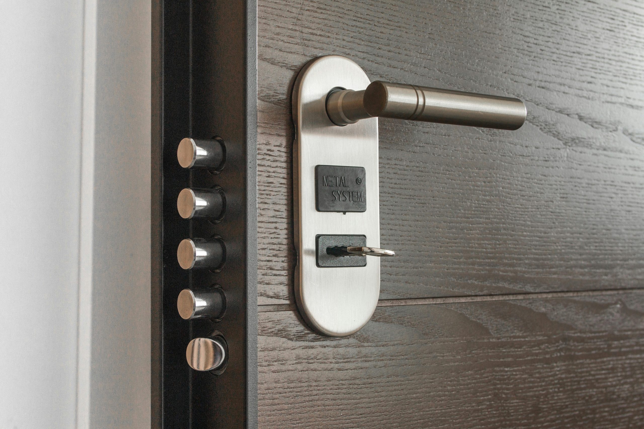 Serrure et poignée de porte en métal avec clé insérée, mettant en avant les caractéristiques de sécurité.