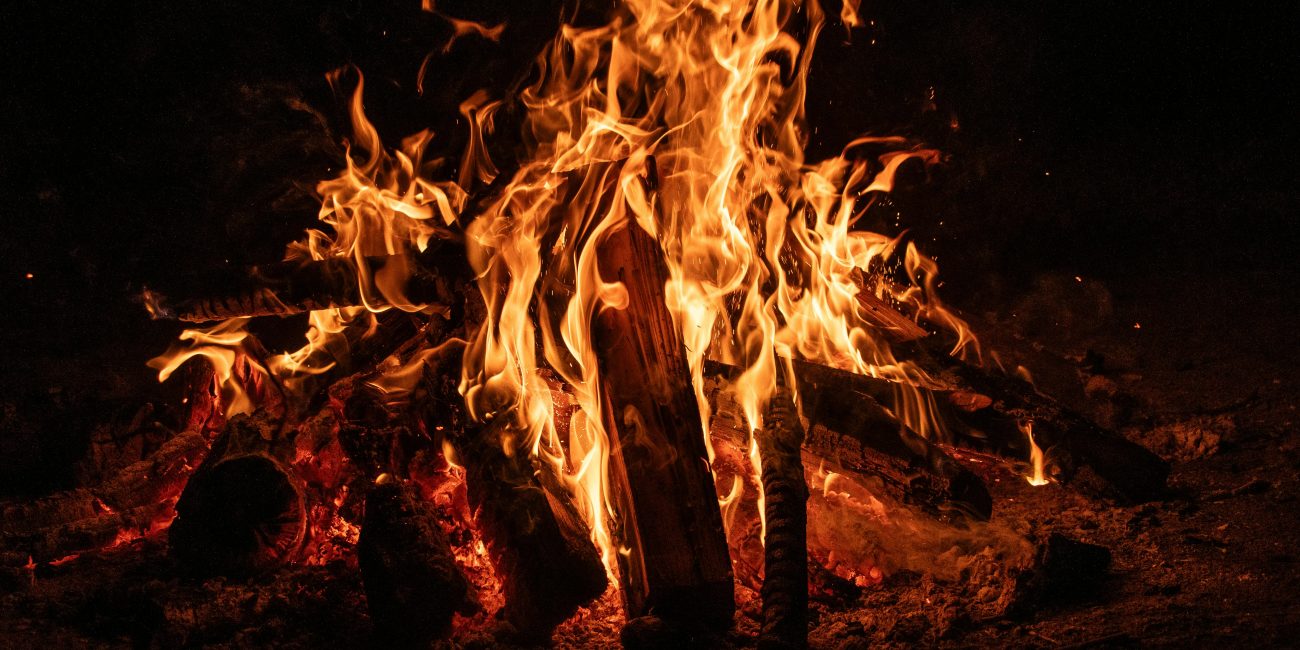 Un feu de camp envoûtant aux flammes vives illuminant la nuit, mettant en valeur la beauté d'un foyer ardent.