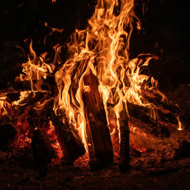 Un feu de camp envoûtant aux flammes vives illuminant la nuit, mettant en valeur la beauté d'un foyer ardent.