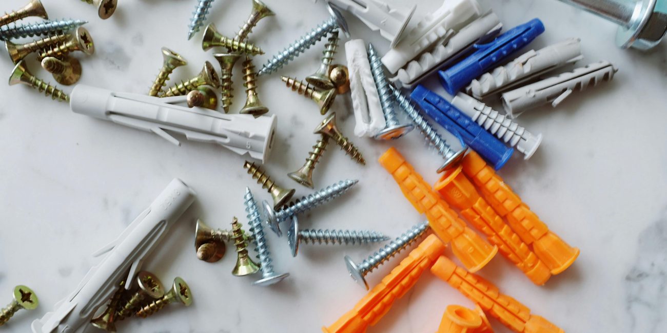 Un arrangement détaillé de vis et de chevilles sur une surface en marbre, idéal pour les projets de bricolage.