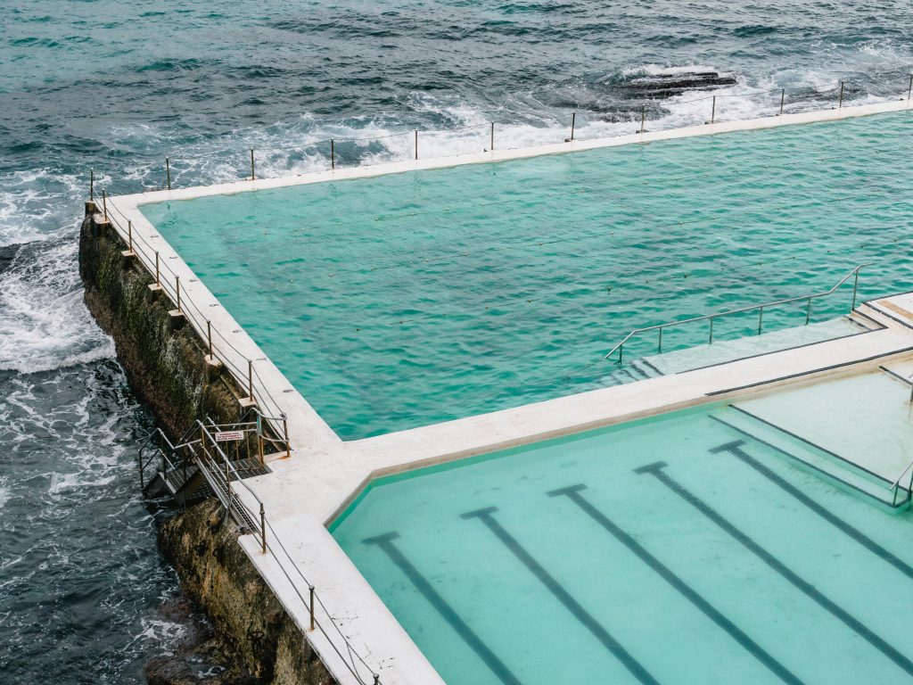 Un plan aérien à couper le souffle capturant la piscine Bondi Icebergs face aux vagues de l'océan.