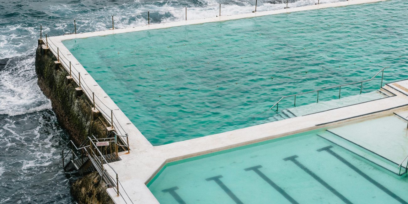 Un plan aérien à couper le souffle capturant la piscine Bondi Icebergs face aux vagues de l'océan.