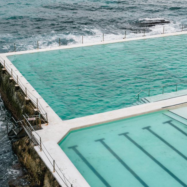 Un plan aérien à couper le souffle capturant la piscine Bondi Icebergs face aux vagues de l'océan.