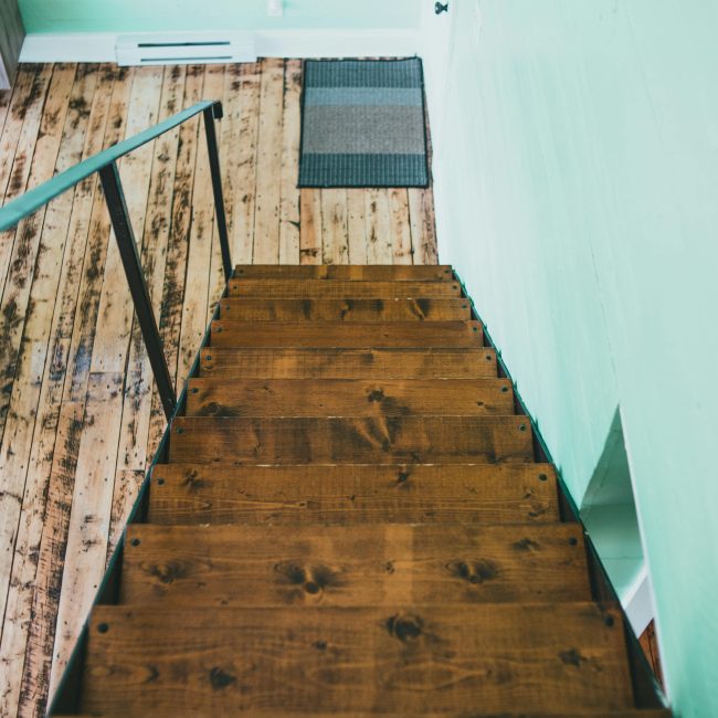 Top-down view d'un escalier en bois rustique contre des murs verts menthe à l'intérieur.