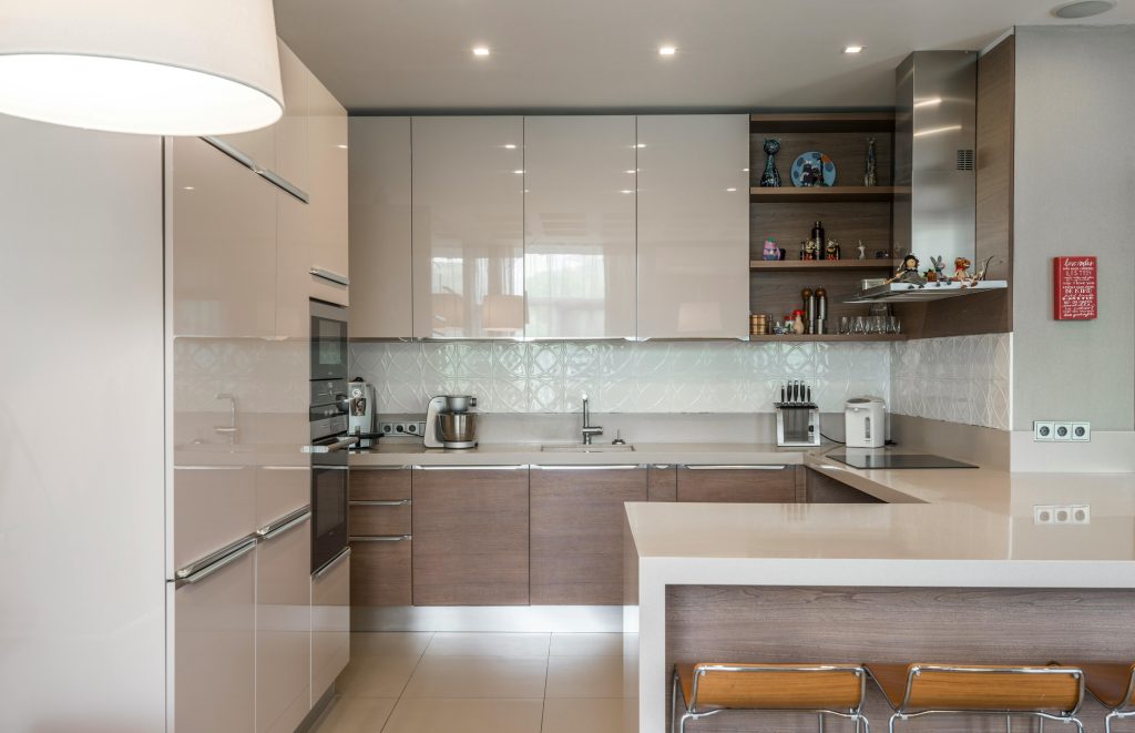 Sleek modern kitchen avec des placards blancs, un îlot et des appareils encastrés.