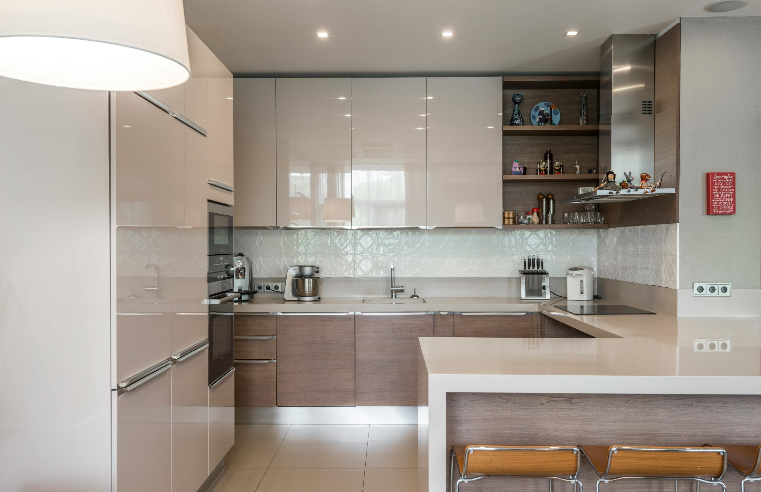 Sleek modern kitchen avec des placards blancs, un îlot et des appareils encastrés.