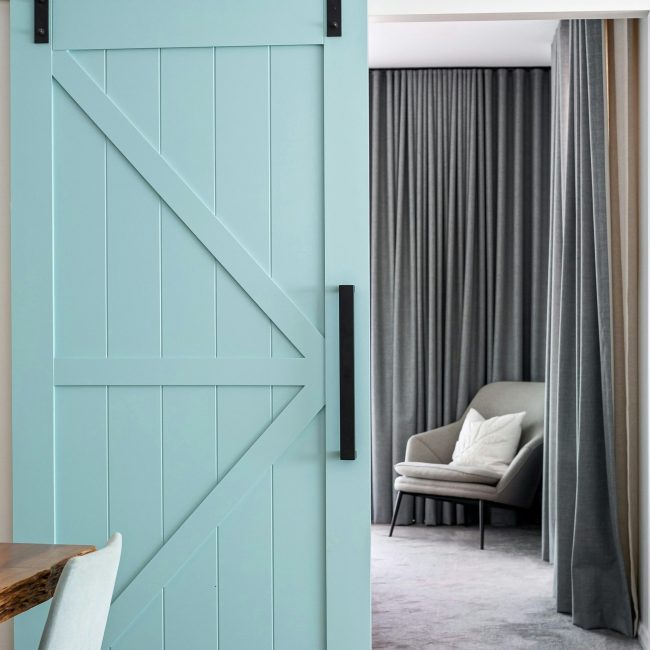Contemporary room avec une porte de grange coulissante et un fauteuil confortable