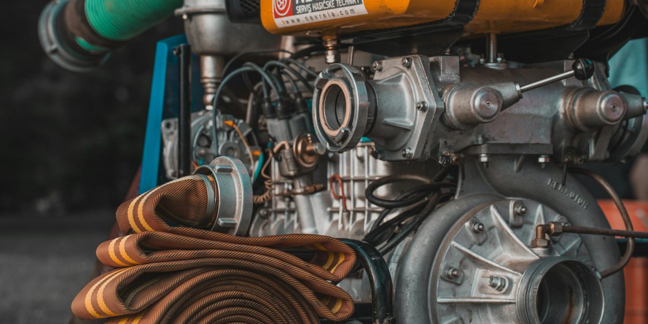 Détail d'une pompe industrielle avec un tuyau enroulé, idéale pour les projets d'eau et d'utilité publique.