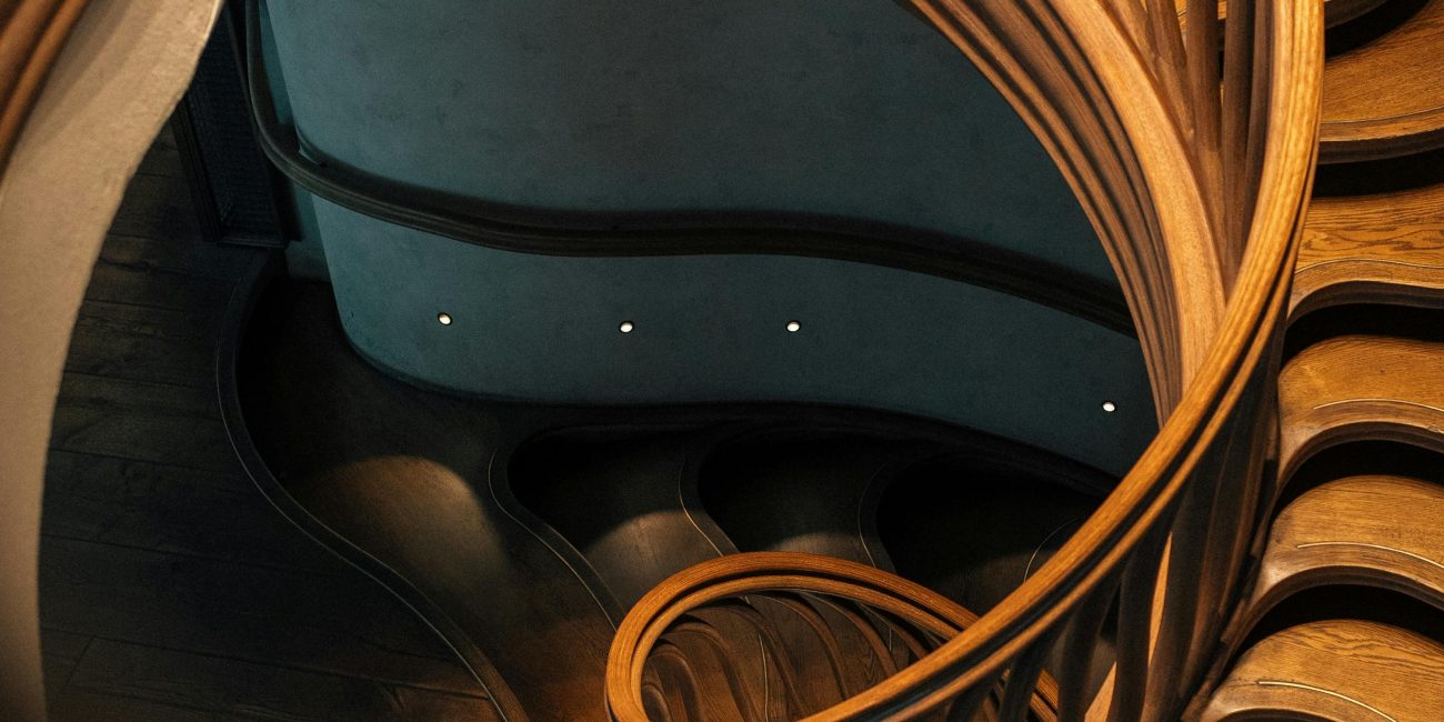 A mesmerizing spiral staircase featuring elegant wooden balustrades in a modern London interior. Un escalier en spirale captivant présentant d'élégantes balustrades en bois dans un intérieur moderne londonien.