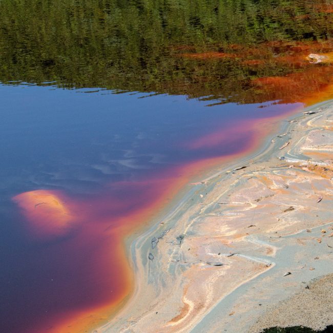 Vibrant hues in Minas de Riotinto lake depicting mineral deposits and reflections. Teintes vibrantes du lac Minas de Riotinto représentant les dépôts minéraux et les reflets.
