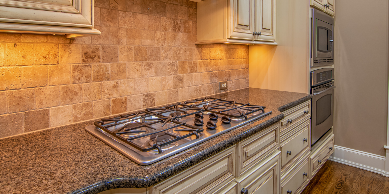 Elegant kitchen featuring granite countertops and stainless steel appliances. Cuisine élégante avec comptoirs en granit et appareils électroménagers en acier inoxydable.