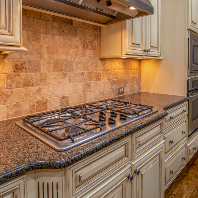 Elegant kitchen featuring granite countertops and stainless steel appliances. Cuisine élégante avec comptoirs en granit et appareils électroménagers en acier inoxydable.