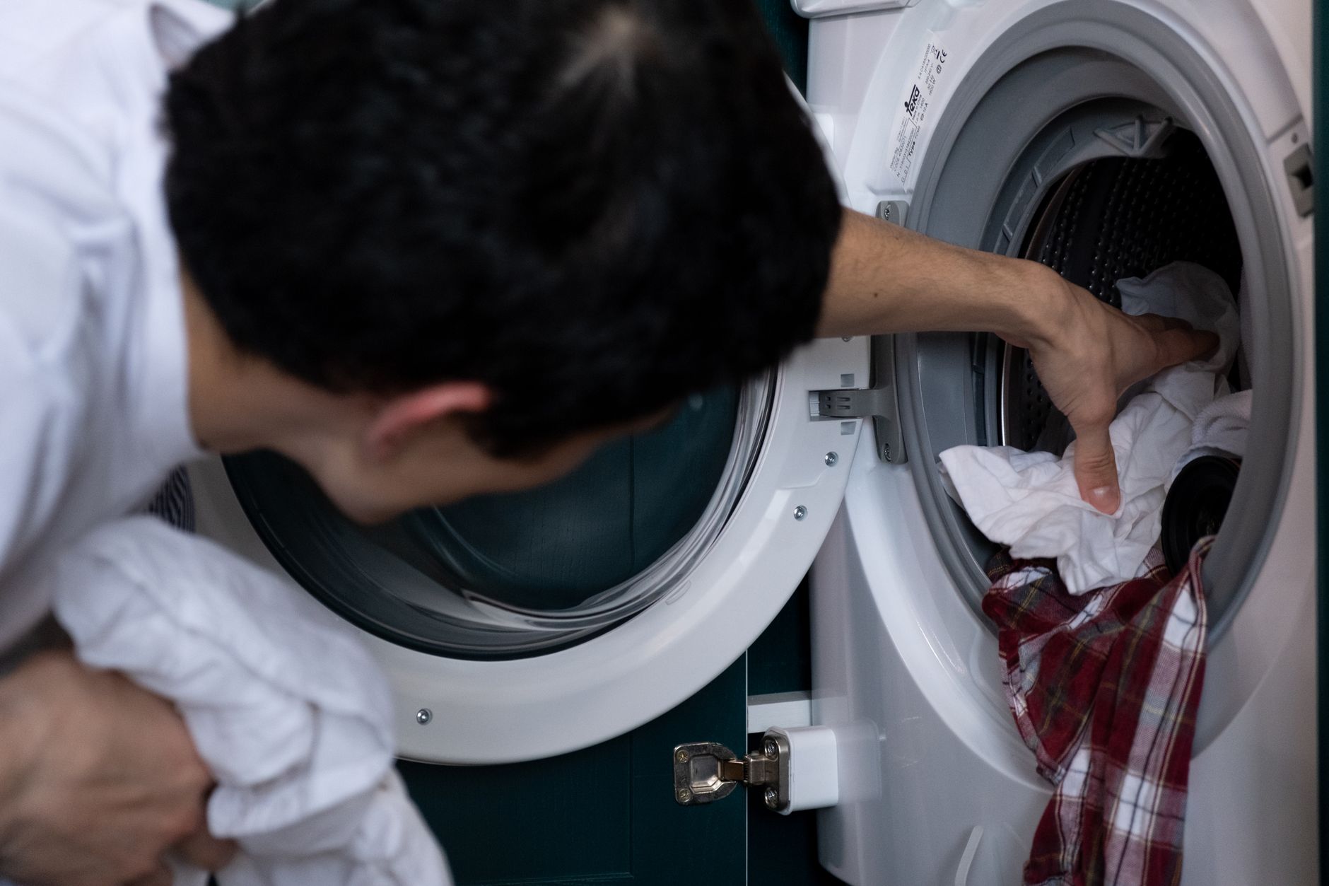 Homme qui charge du linge dans une machine à laver