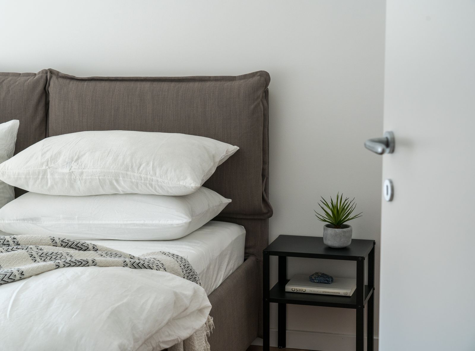 Chambre pour invités avec lit fait et linge clair
