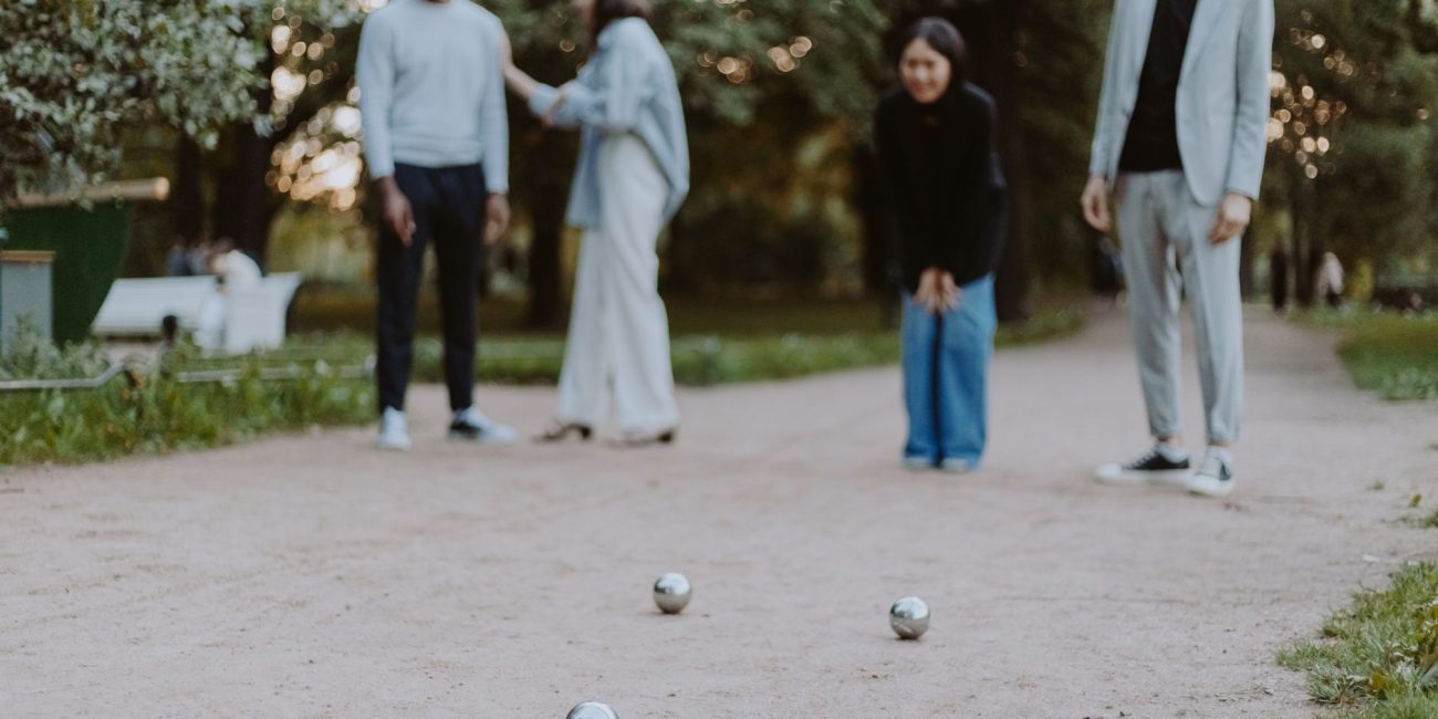 Partie de pétanque entre amis dans un parc