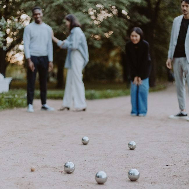 Partie de pétanque entre amis dans un parc