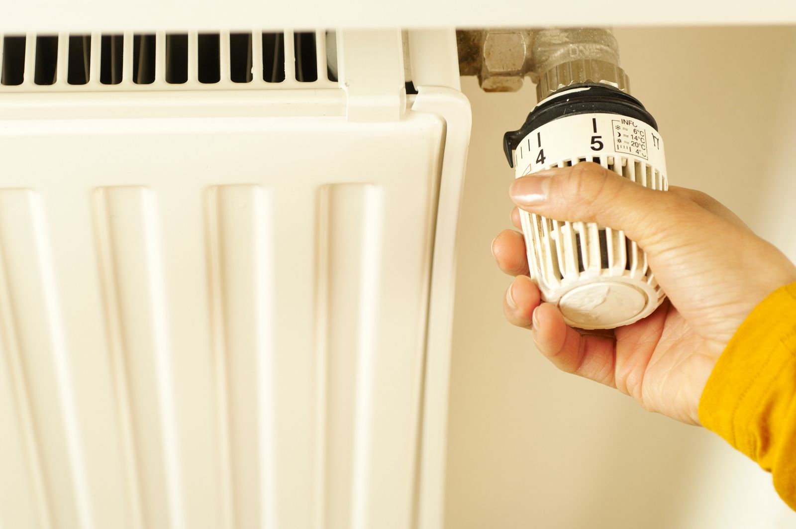 Main réglant le robinet thermostatique d un radiateur