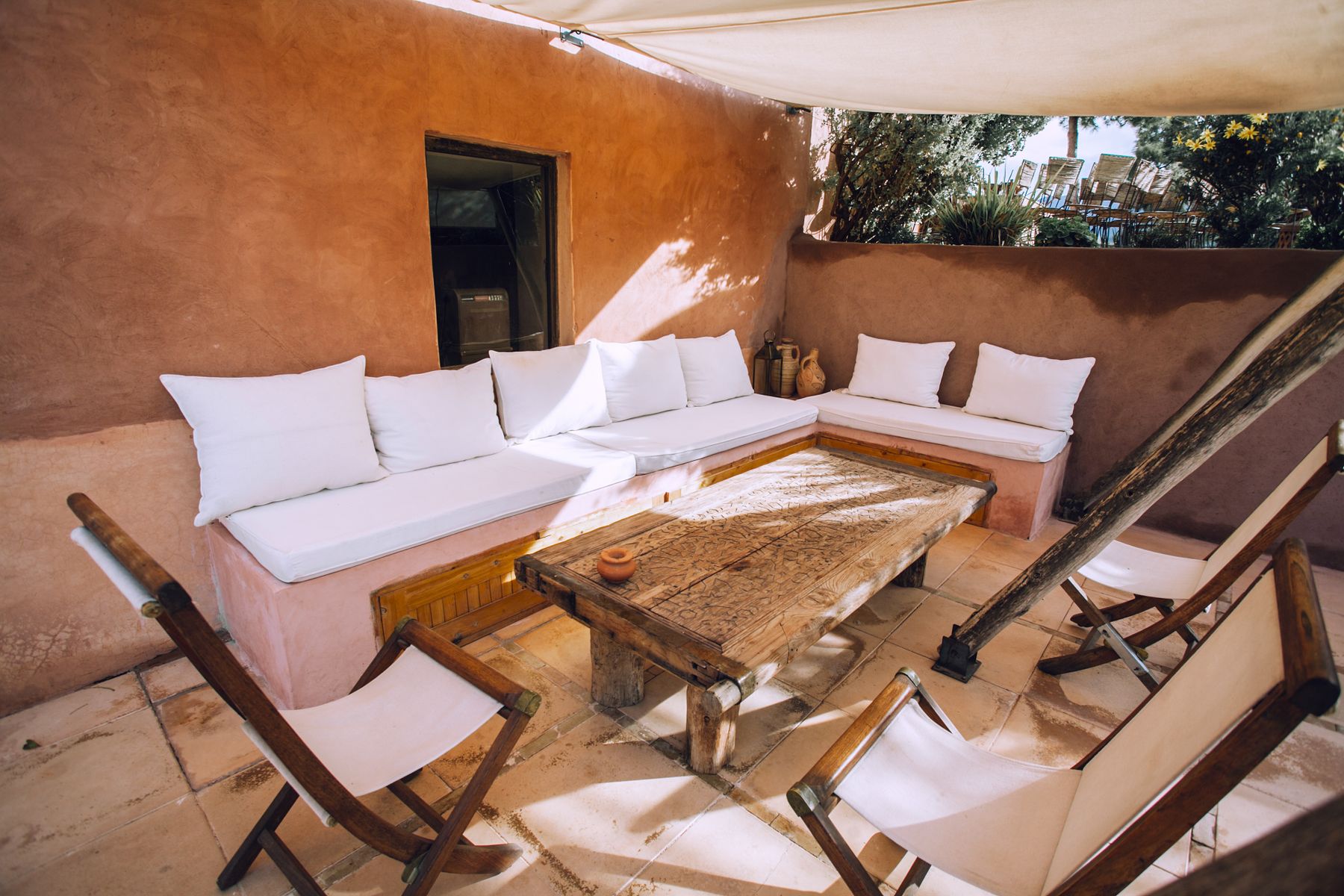 Véranda ombragée avec table et chaises en bois