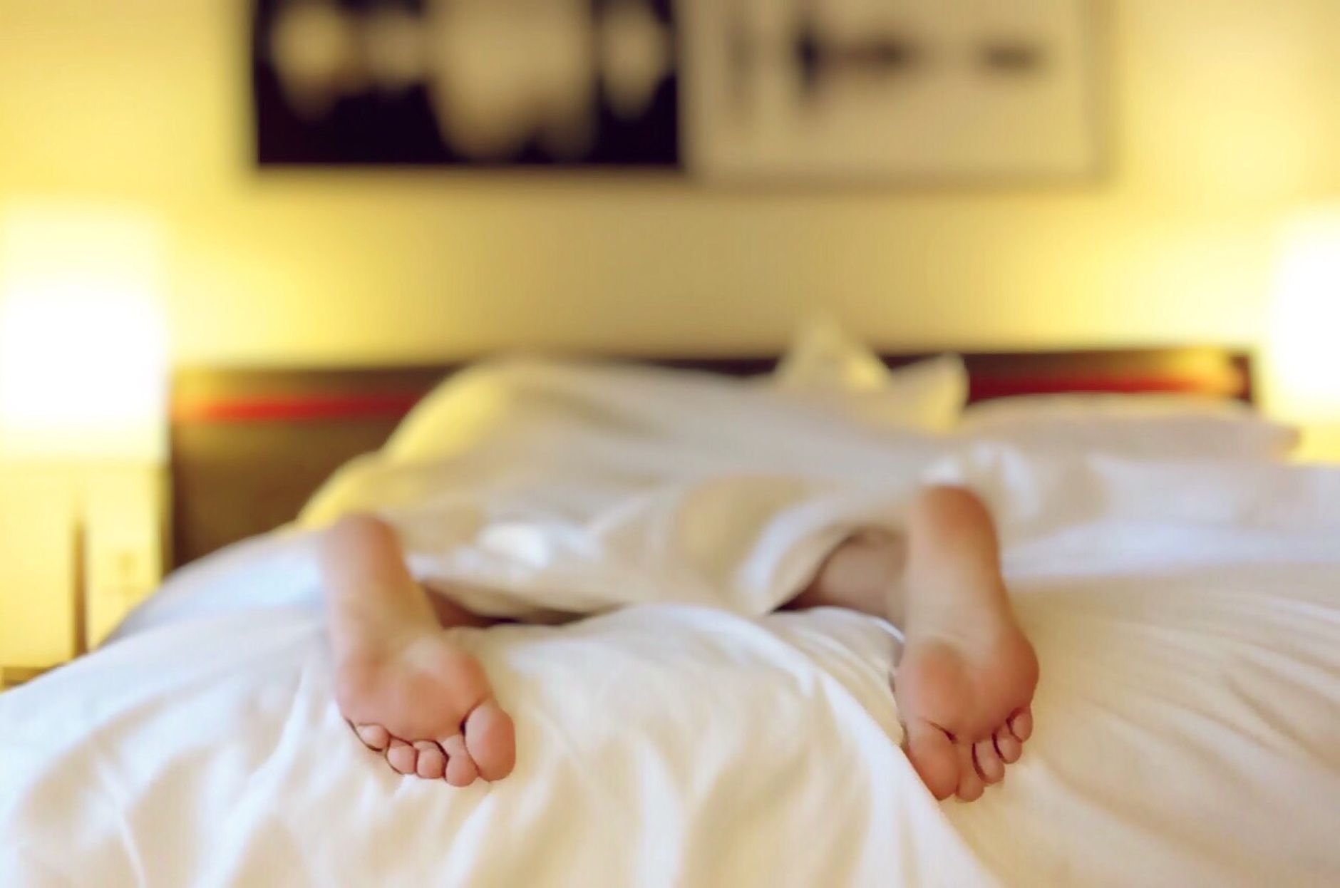 Personne allongée dans un lit aux draps blancs
